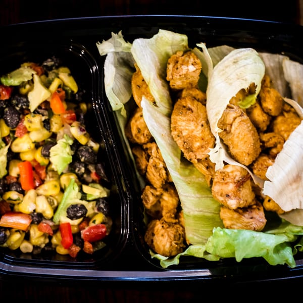 Chicken lettuce wraps with a side of corn, black bean, avocado, and red pepper salad.