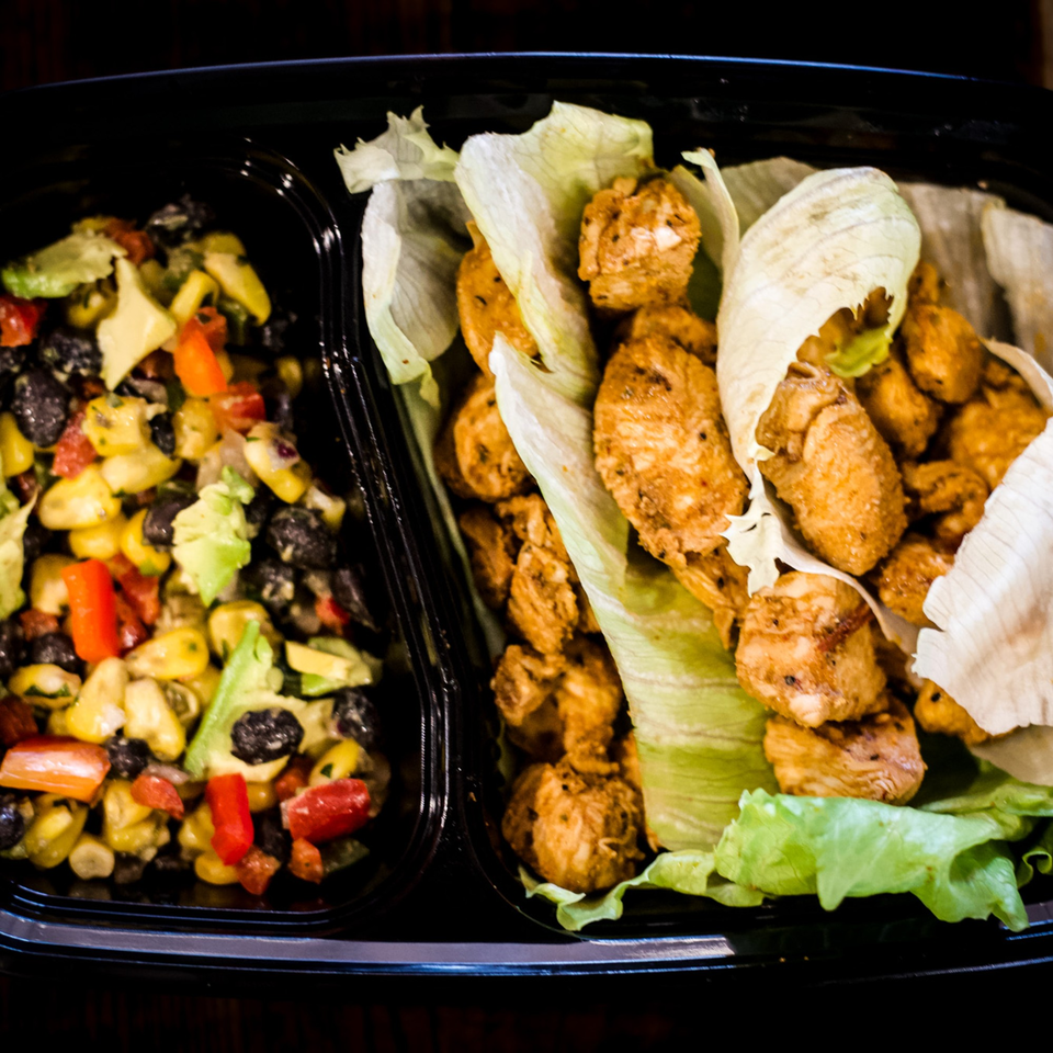 Chicken lettuce wraps with a side of corn, black bean, avocado, and red pepper salad.